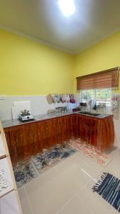 a kitchen with yellow walls and a wooden counter top at Nur Homestay in Kapar