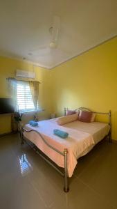 a bedroom with a bed in a yellow room at Nur Homestay in Kapar