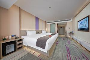 a hotel room with a large bed and a tv at Lavande Hotels Guangzhou Panyu Hanxi Changlong Dashi Subway Station in Guangzhou +16 photos