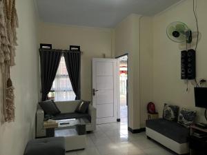 a living room with a couch and a chair at Homestay A51 in Panjalu