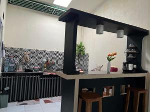 a kitchen with a counter and chairs in a room at Homestay A51 in Panjalu