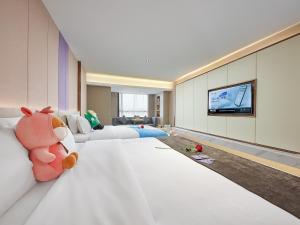 a large room with a bed and a tv at Lavande Hotel Guangzhou Panyu Hanxi Changlong Dashi Subway Station in Guangzhou