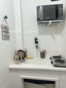 a kitchen counter with a microwave and a sink at Stúdio no Centro- Lapa, Consulado, Praia e Metrô! 1101 in Rio de Janeiro