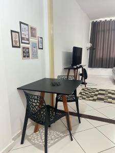 a black table and a chair in a living room at Stúdio no Centro- Lapa, Consulado, Praia e Metrô! 1101 in Rio de Janeiro +1 photo