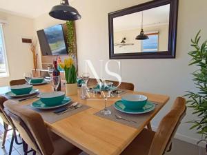 a dining room with a wooden table with chairs and a mirror at Casa Perfecta para Vacaciones Familiares -Vista al Volcán - Parking Free in Villarrica +15 photos