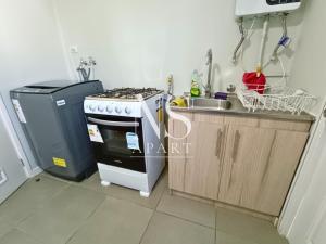 a kitchen with a stove top oven next to a sink at Casa Perfecta para Vacaciones Familiares -Vista al Volcán - Parking Free in Villarrica