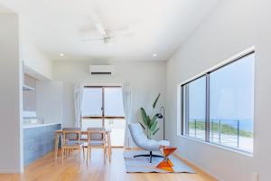 宫古岛Cliff Sky的带桌椅和大窗户的客厅