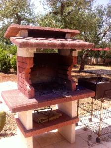 un forno per pizza in mattoni seduto sopra un patio di Il Trullo di Giulietta a Impalata
