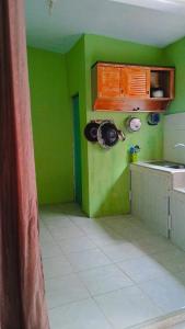 a kitchen with green walls and white tile floors at Villa Higland No 7 P Berastagi View in Berastagi