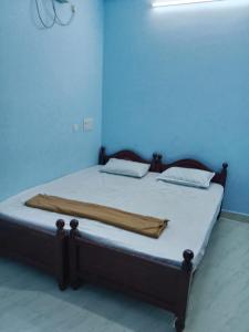 a bed in a blue room with a blanket on it at Uddish Residency in Virāmpattinam +18 photos