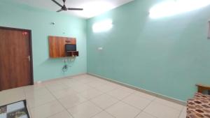 a living room with a ceiling fan and blue walls at Uddish Residency in Virāmpattinam