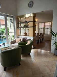 a living room with a couch and chairs and a table at Omah Kumpul Sentul in Bogor +18 photos