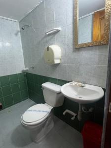 a bathroom with a toilet and a sink at Hotel Georgina in Barranquilla