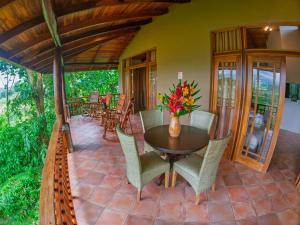 a dining room with a table and chairs on a patio at Lost Iguana Resort and Spa in Fortuna