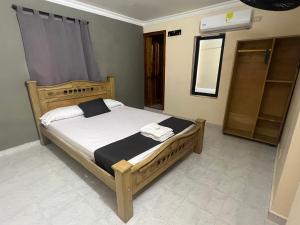 巴兰基亚Hotel Georgina的一间卧室配有一张带白色床单和镜子的床