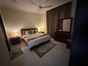 塞拉莱Gloria Suites اجنحة جلوريا的带一张大床和一面镜子的卧室