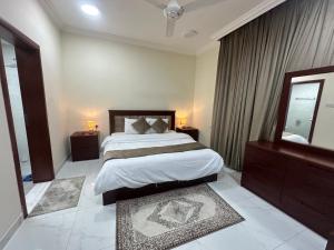 サラーラにあるGloria Suites اجنحة جلورياの大きなベッドと大きな鏡のある寝室