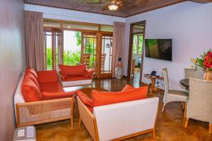 a living room with orange and white furniture at Lost Iguana Resort and Spa in Fortuna