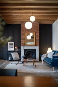 Una sala de estar con un sofá y una chimenea. en Luxury Historic Landmark Holdgates Cottage, en Brisbane