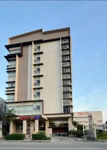 a tall apartment building with a parking lot at District 21 Hotel in Iloilo City