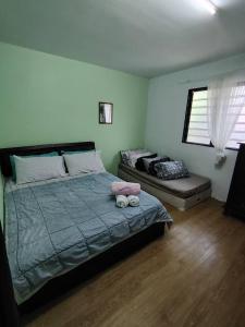 a bedroom with a large bed and a window at Aziqa Homestay Chalet With Pool in Alor Tampang