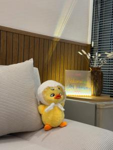 a rubber duck sitting on a bed with a towel on its head at Gần Homestay - Nha Trang in Nha Trang