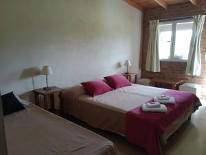 a bedroom with two beds with towels on them at La Chacra Hotel Campo y Spa in San Pedro +23 photos