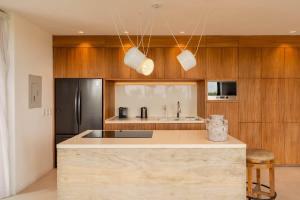 een keuken met een aanrecht en een koelkast bij Galeria Privada - Tulum Hidden Masterpiece in Tulum