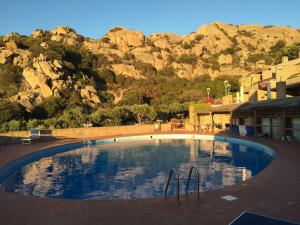 una grande piscina con una montagna sullo sfondo di Residence Scala Chiusa a Baja Sardinia