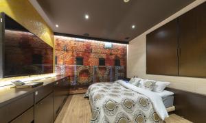 a bedroom with a bed and a brick wall at ホテルパサディナ11郡山 in Koriyama