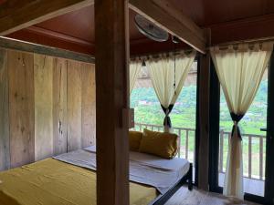 ein Schlafzimmer mit einem Bett und einem Balkon in der Unterkunft Cương Mountain View Homestay in Yên Minh + 3 Fotos