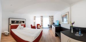 a hotel room with a bed and a desk with a television at Hotel Adler Post in Schwetzingen