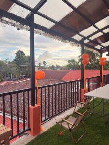 a balcony with a table and chairs and a stadium at 8-Bed Mixed Dorm, Surf & Social Hostel Siargao in General Luna