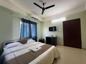 a bedroom with a bed with a ceiling fan at DXK Villa Homestay in Guwahati