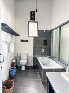 a bathroom with a tub and a toilet and a sink at Marleys Beach House in Talpe