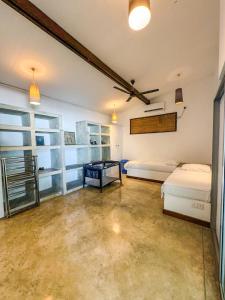 a bedroom with two beds and a table in it at Marleys Beach House in Talpe