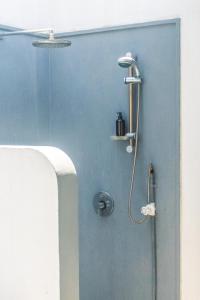 y baño con ducha y pared azul. en Marleys Beach House, en Talpe