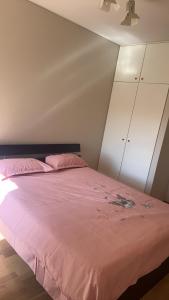 a bedroom with a bed with pink sheets and a ceiling at Comfort Home For You豪华双人间2 in Perth