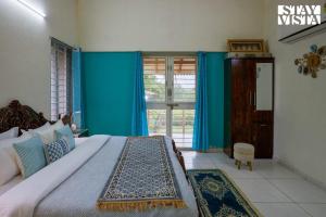 a bedroom with a large bed with blue walls at Whispers of Green by VEO - Part of StayVista in Trimbak