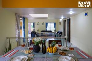 a dining room table with food and wine glasses at Whispers of Green by VEO - Part of StayVista in Trimbak