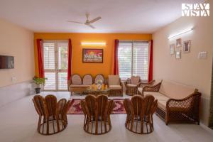 a living room with a couch and chairs at Whispers of Green by VEO - Part of StayVista in Trimbak