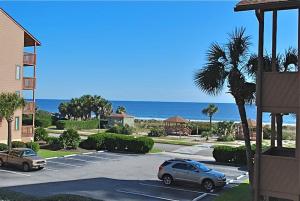 a parking lot with cars parked in front of the ocean at Anchorage II B04 in Myrtle Beach