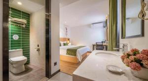 a hotel room with a bed and a bathroom at Green Tree Inn Guangxi Wuzhou 2nd Xinxing Road Liangguang Market in Wuzhou +213 photos