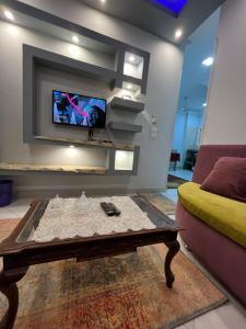 a living room with a coffee table and a tv at Roma Apartment LXR in Luxor