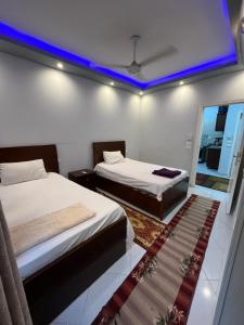two beds in a room with a blue ceiling at Roma Apartment LXR in Luxor