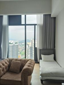 un salon avec un canapé et une grande fenêtre dans l'établissement Star KLCC By B&B, à Kuala Lumpur