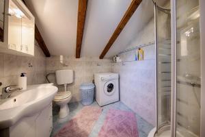 a bathroom with a sink toilet and a washing machine at Apartments Pol Murvu in Vis +36 photos