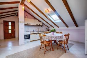 a kitchen with a table and chairs in a room at Apartments Pol Murvu in Vis
