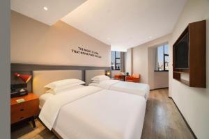 a hotel room with three beds and a flat screen tv at Premier City Comfort Hotel Wuhan Yellow Crane Shouyi Road Metro Station in Wuhan +272 photos