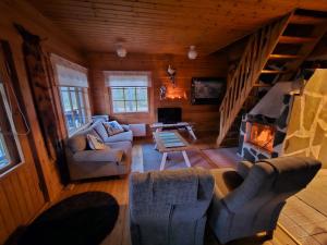 a living room with couches and a fireplace in a cabin at Pyhä Aava in Pyhätunturi